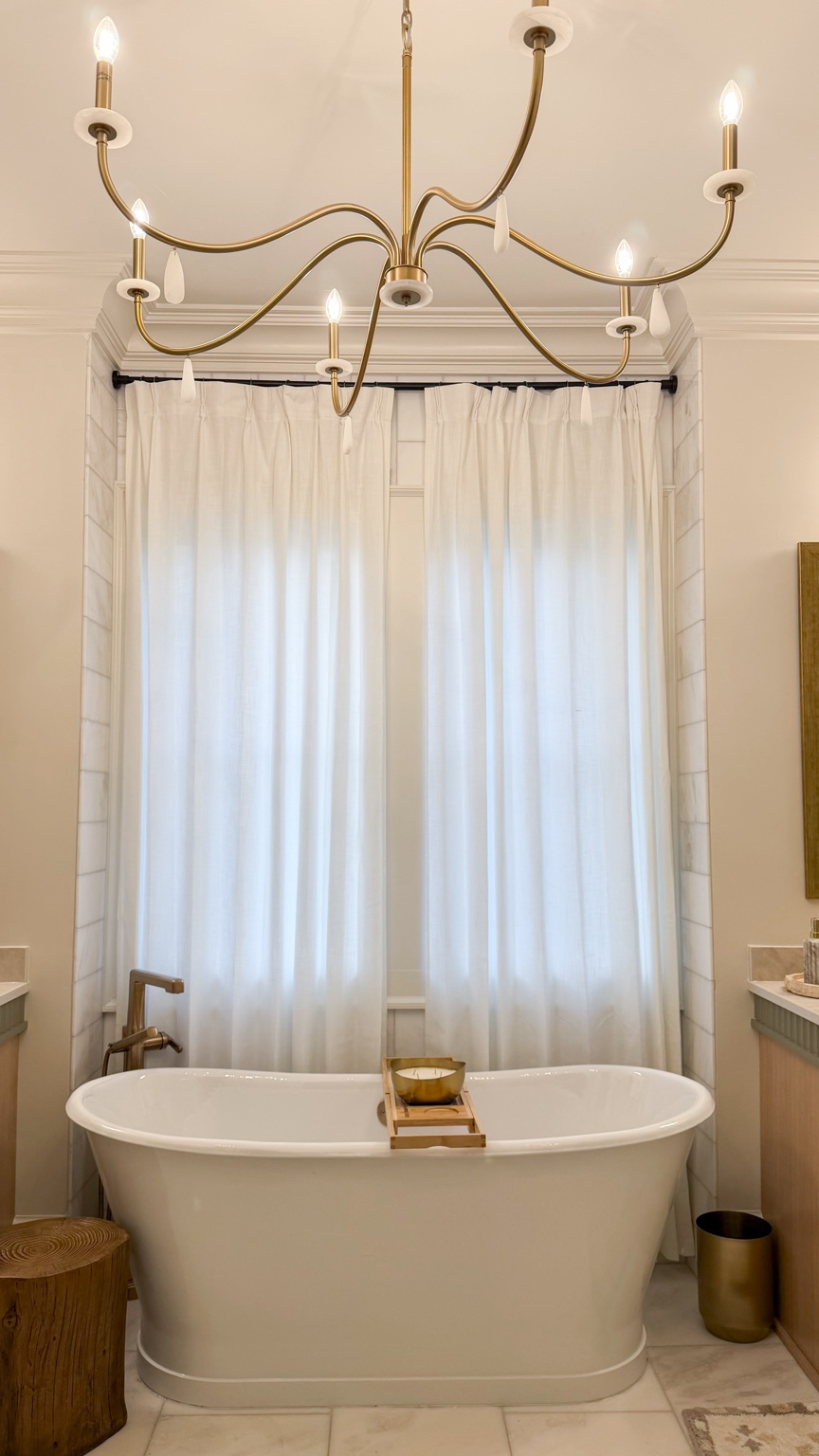 Audubon Suite freestanding bathtub beneath a brass chandelier