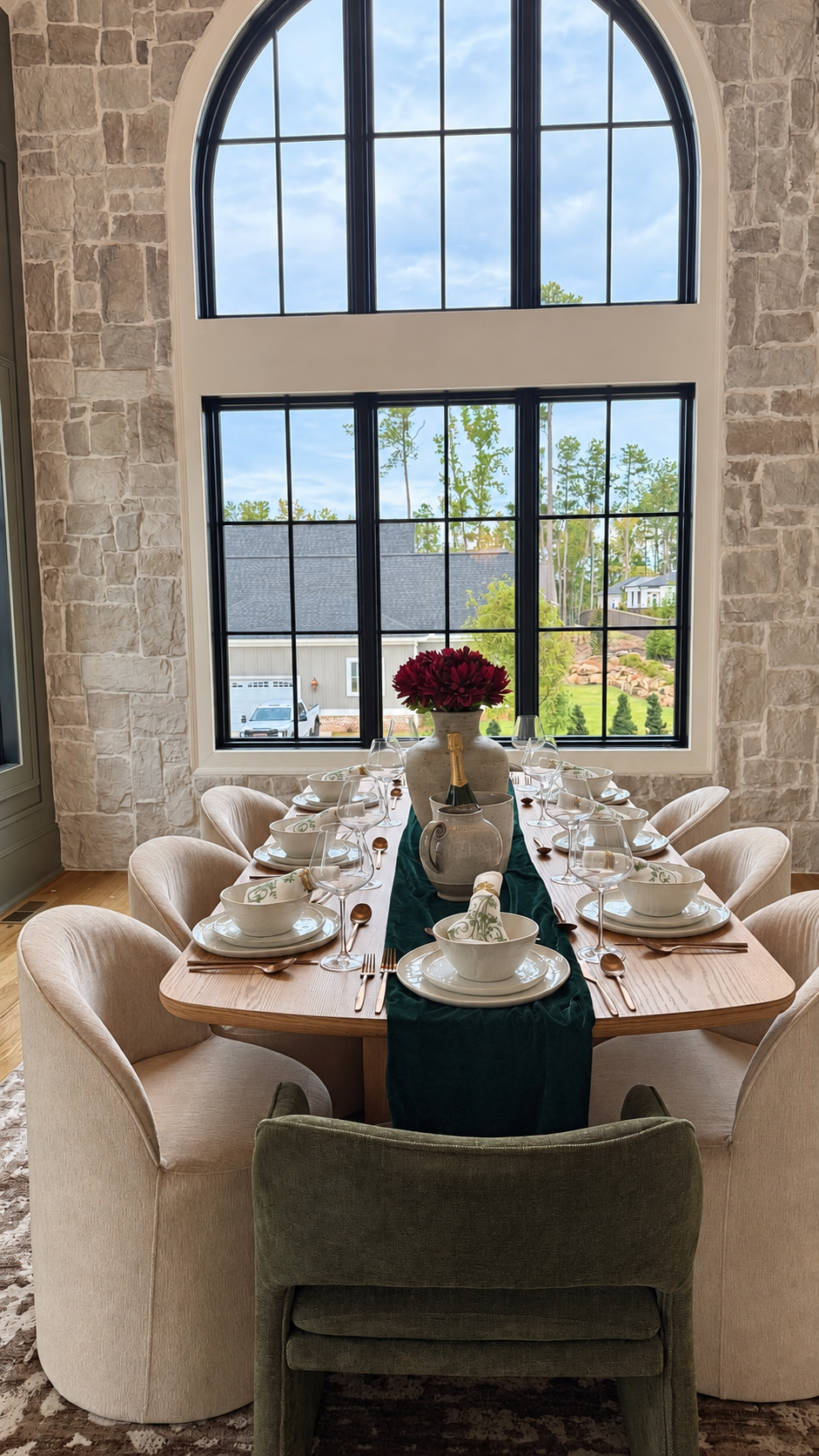 Dining table beneath the large arched window