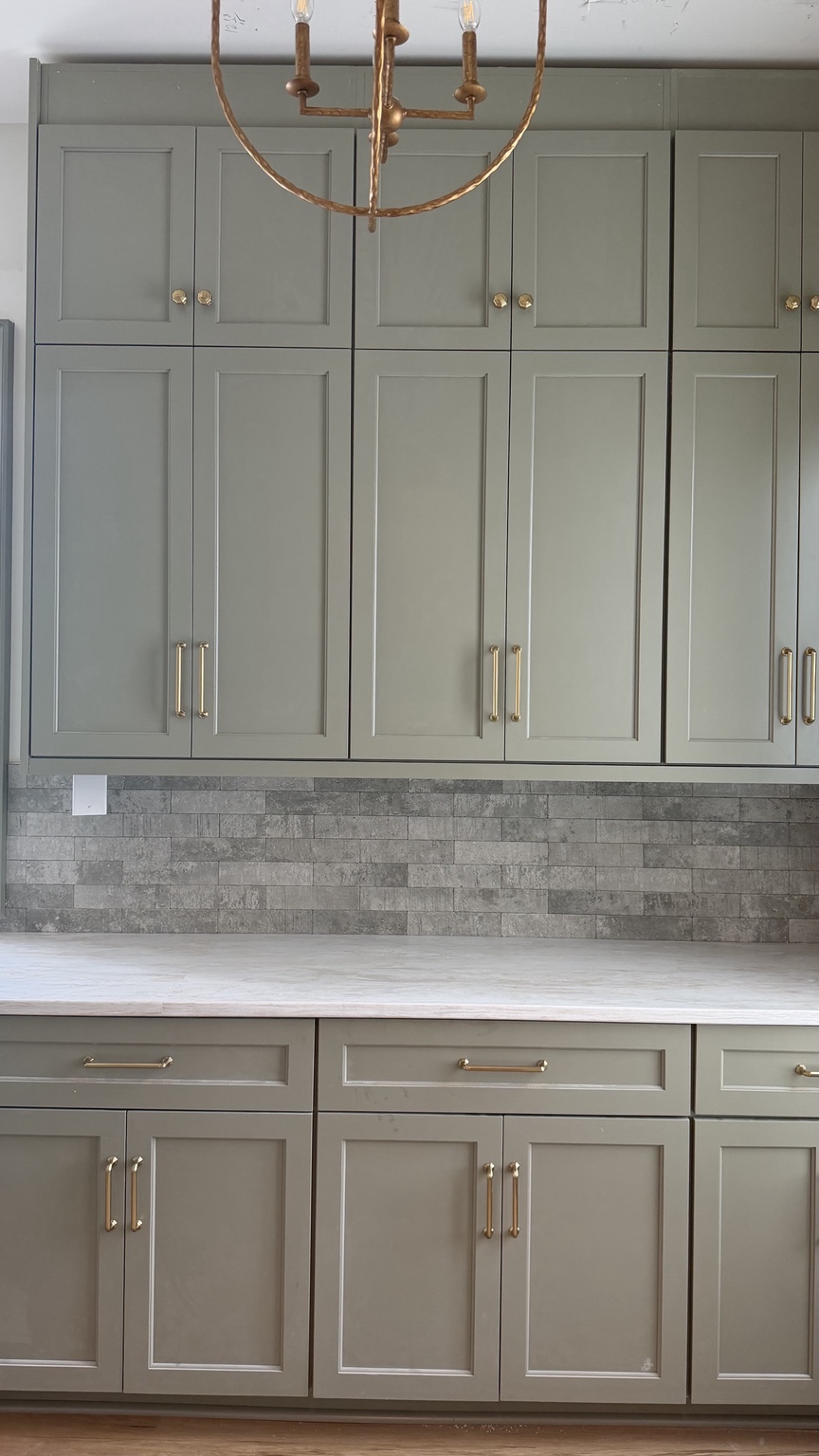 Green butler pantry cabinetry and stone backsplash