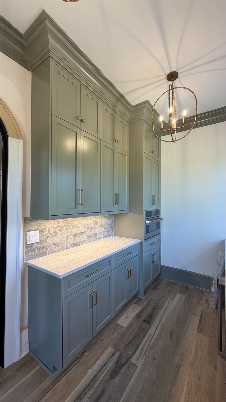 Butler pantry cabinetry, microwave and chandelier