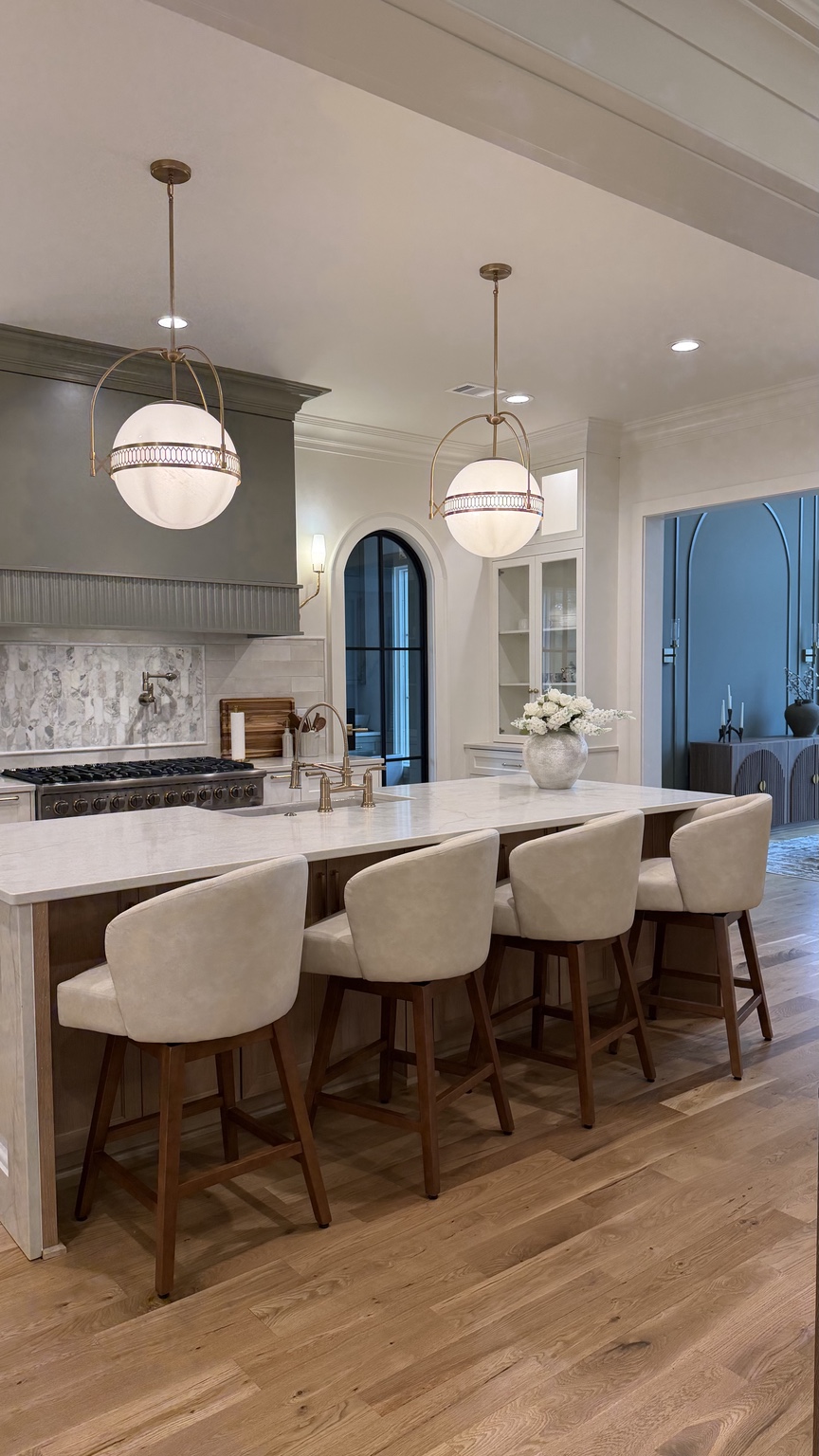 Kitchen island with four stools and globe pendants