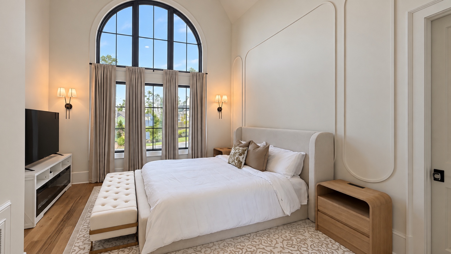 The Meridian Suite California king bed, television, and arched window wall